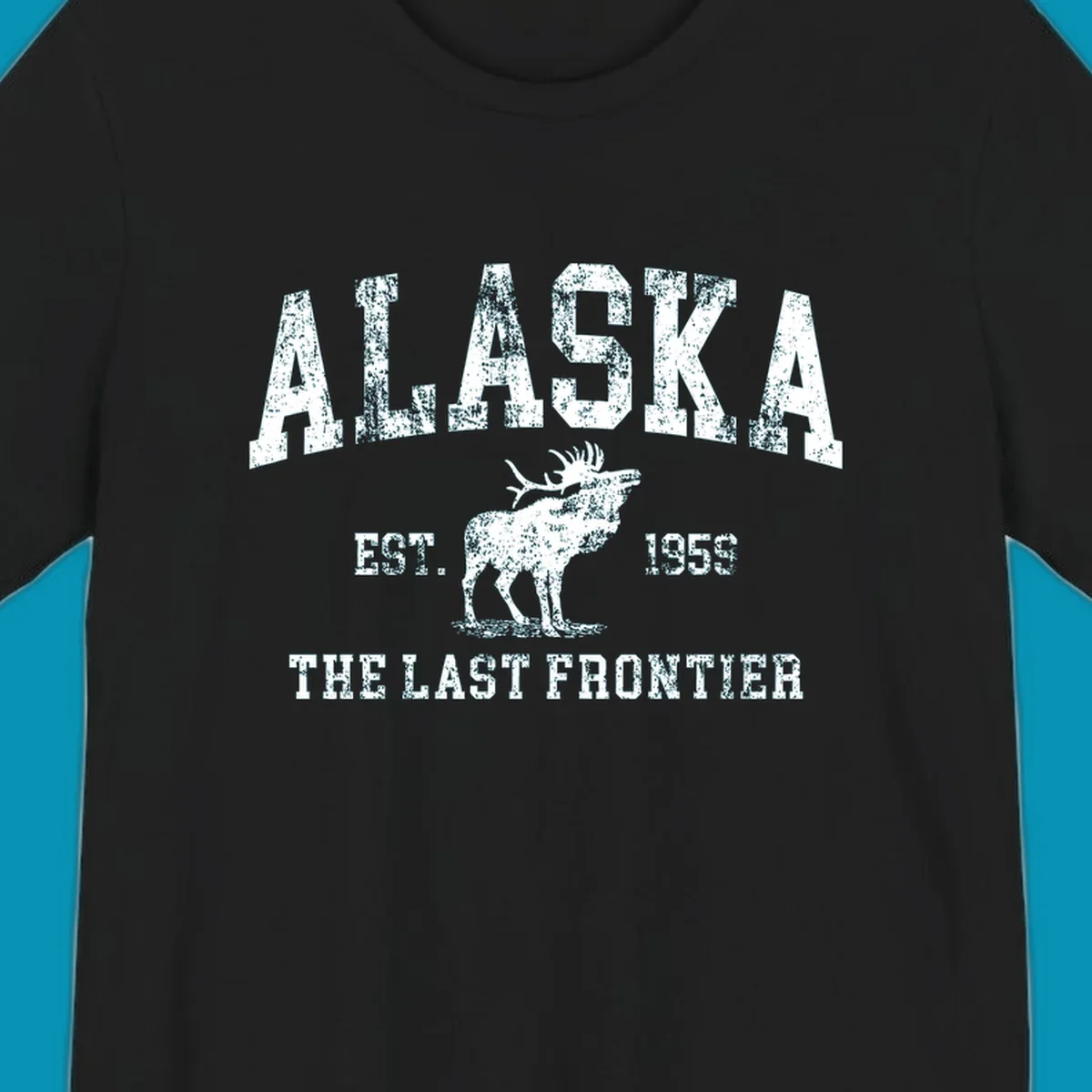 Distressed white design featuring a moose and the text ALASKA THE LAST FRONTIER.
