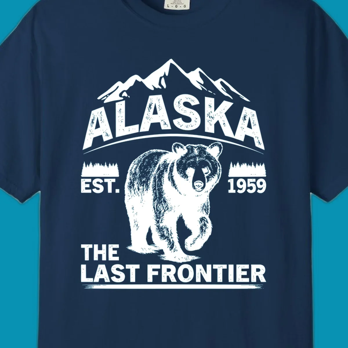 White graphic of a walking grizzly bear under mountain peaks with alaska-grizzly-frontier-mountains text.