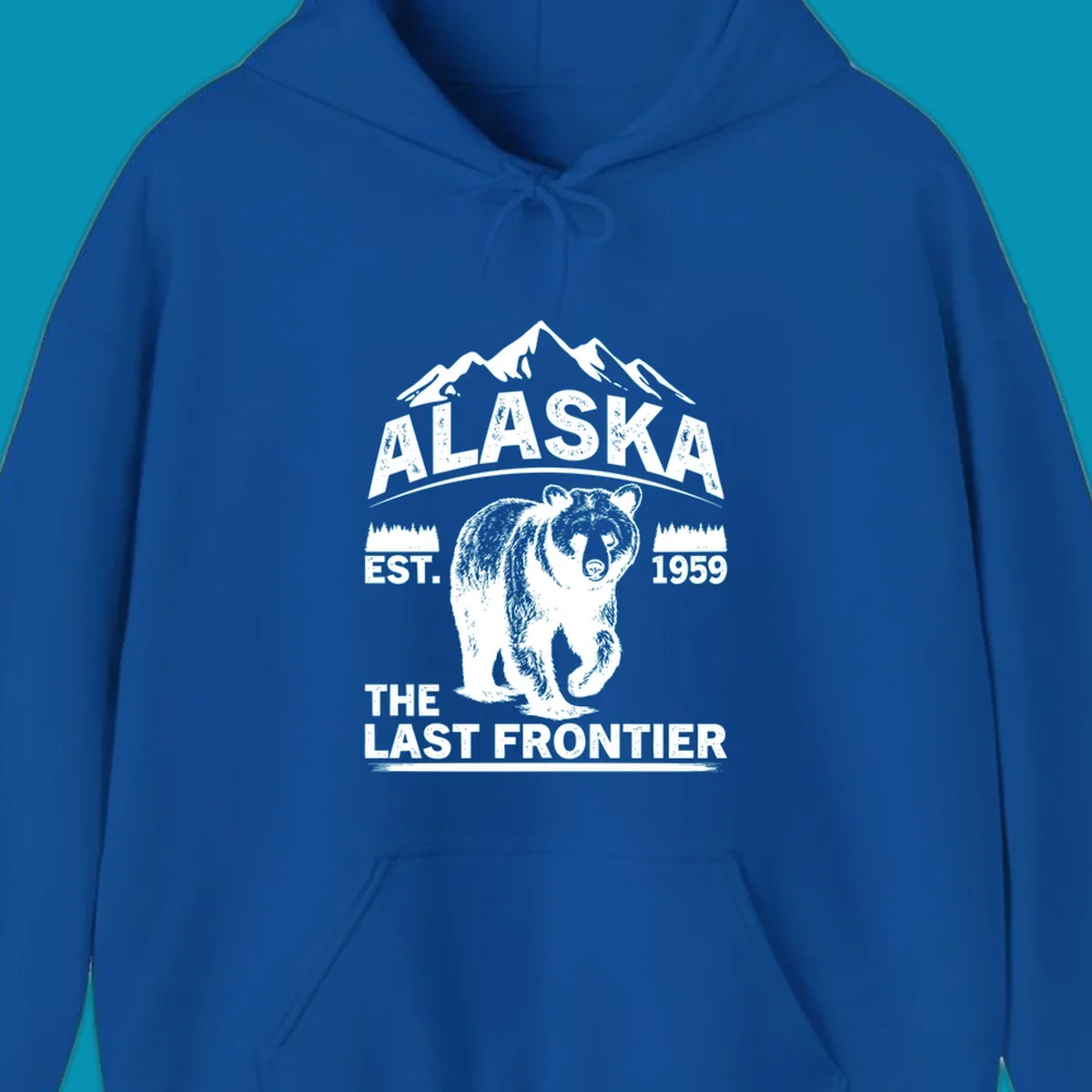 White graphic of a walking grizzly bear under mountain peaks with alaska-grizzly-frontier-mountains text.