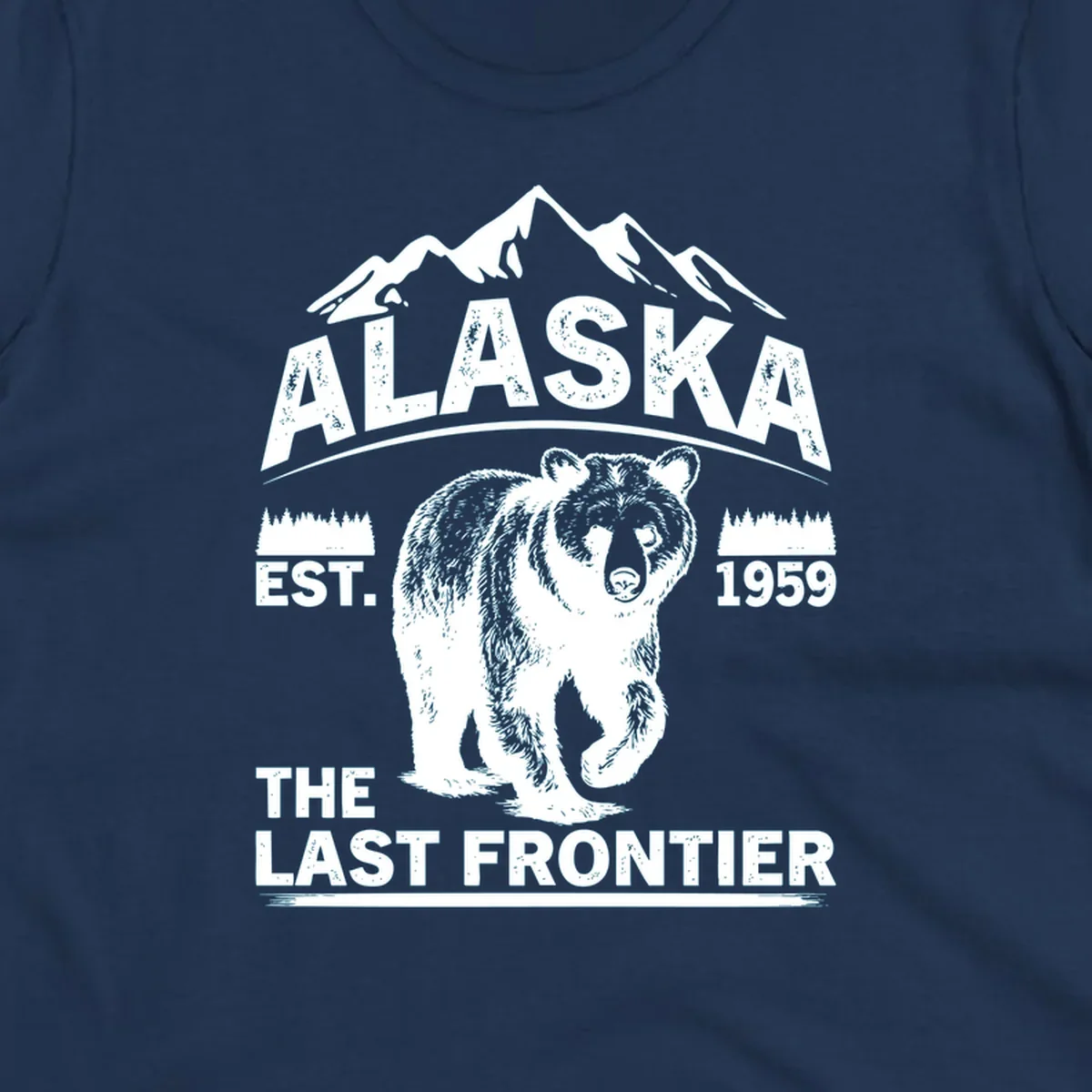 White graphic of a walking grizzly bear under mountain peaks with alaska-grizzly-frontier-mountains text.