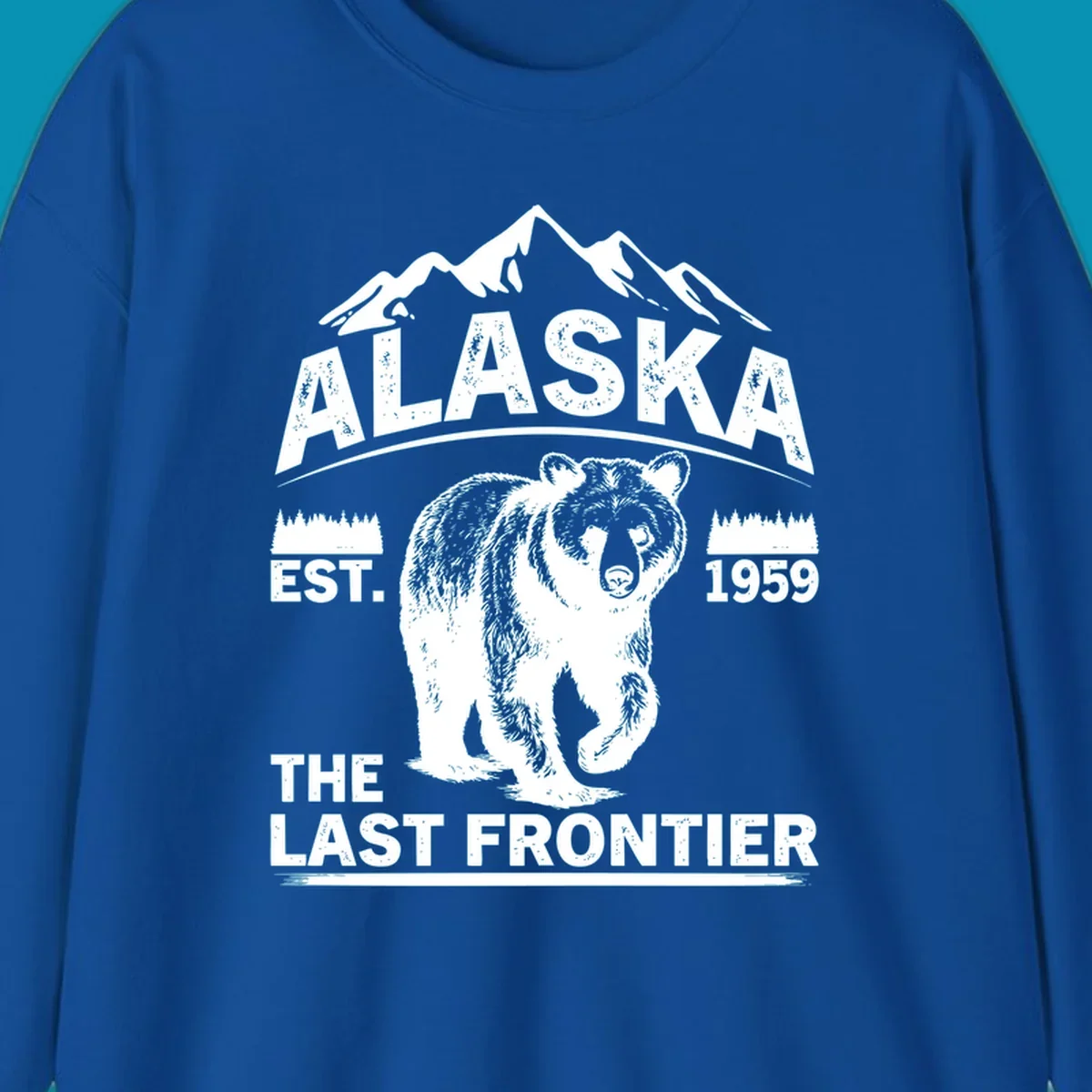White graphic of a walking grizzly bear under mountain peaks with alaska-grizzly-frontier-mountains text.
