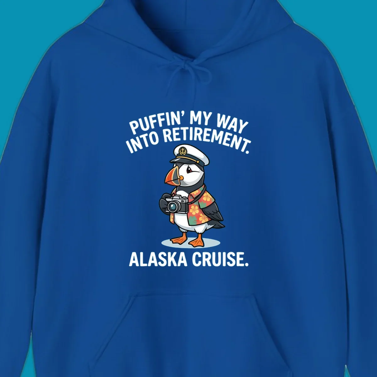 A cartoon puffin wearing a captain's hat and Hawaiian shirt holds a camera, with text 'PUFFIN' INTO MY RETIREMENT. ALASKA CRUISE.' for a puffin-into-retirement-cruise.