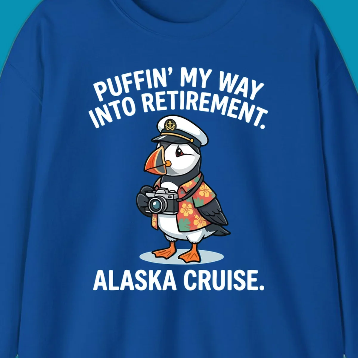 A cartoon puffin wearing a captain's hat and Hawaiian shirt holds a camera, with text 'PUFFIN' INTO MY RETIREMENT. ALASKA CRUISE.' for a puffin-into-retirement-cruise.