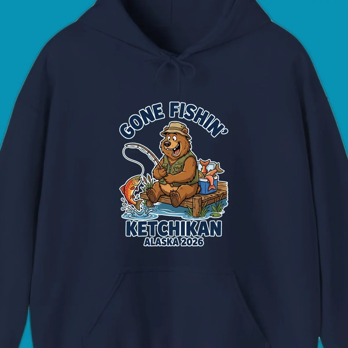 Cartoon bear in hat and vest fishing from a dock, with a fish on the line and cooler. Text: 'GONE FISHIN' KETCHIKAN ALASKA 2026'. Ideal for a gone-fishin-ketchikan-bear themed Alaska cruise.