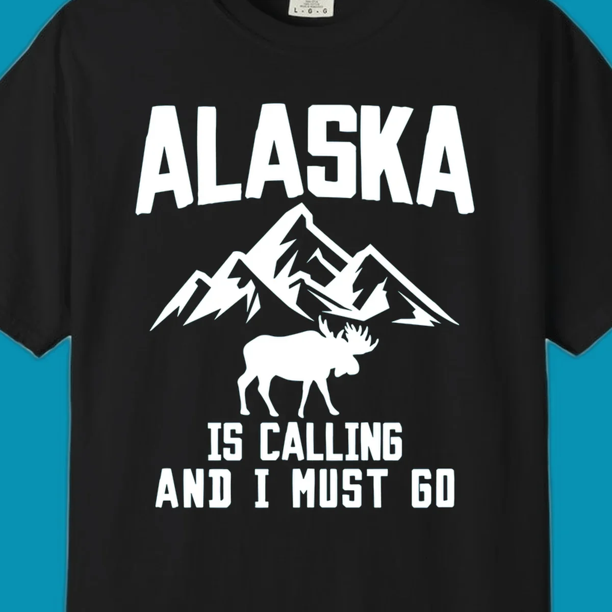 White moose silhouette and snow-capped mountains with text reading Alaska is calling and I must go