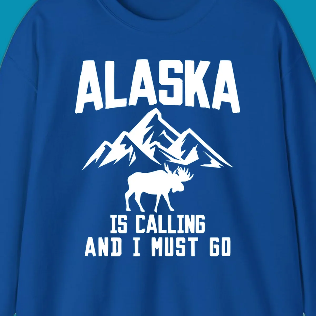 White moose silhouette and snow-capped mountains with text reading Alaska is calling and I must go