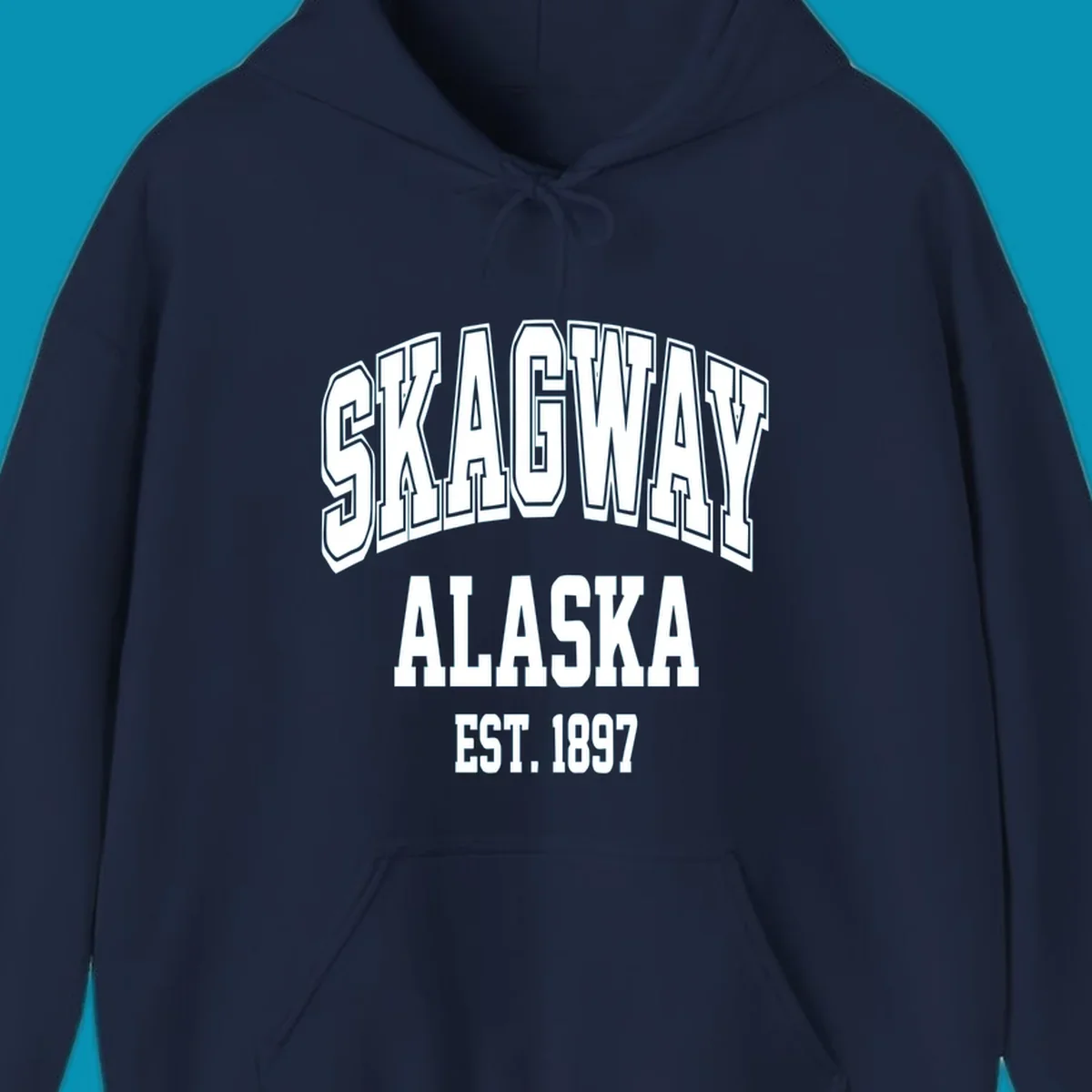 Vintage-style badge with bold outlined text reading Skagway Alaska Est. 1897 with decorative arrow accents on gray background.