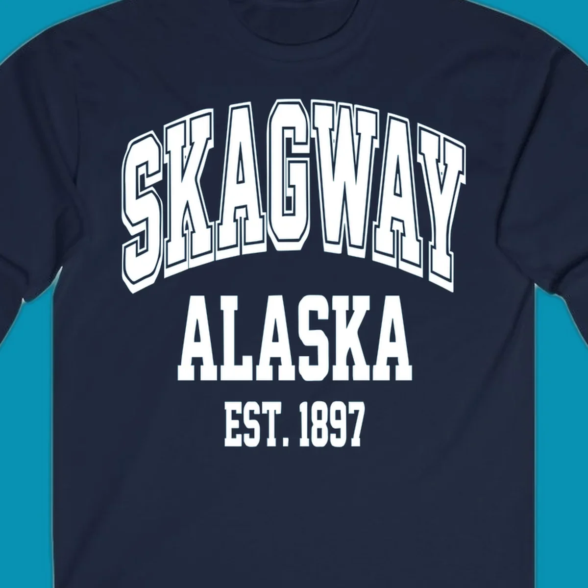 Vintage-style badge with bold outlined text reading Skagway Alaska Est. 1897 with decorative arrow accents on gray background.