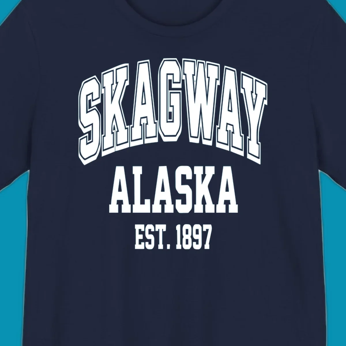 Vintage-style badge with bold outlined text reading Skagway Alaska Est. 1897 with decorative arrow accents on gray background.