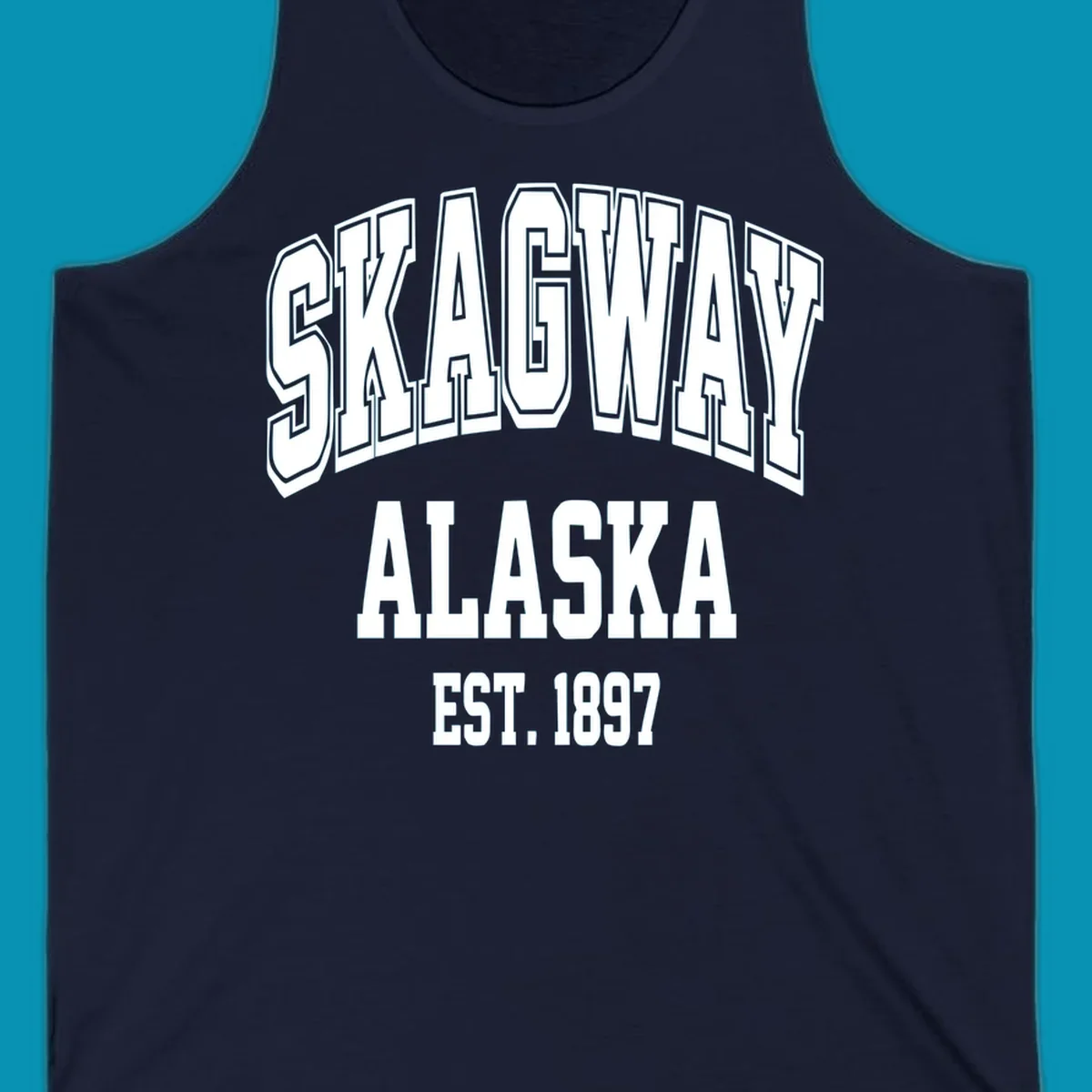 Vintage-style badge with bold outlined text reading Skagway Alaska Est. 1897 with decorative arrow accents on gray background.