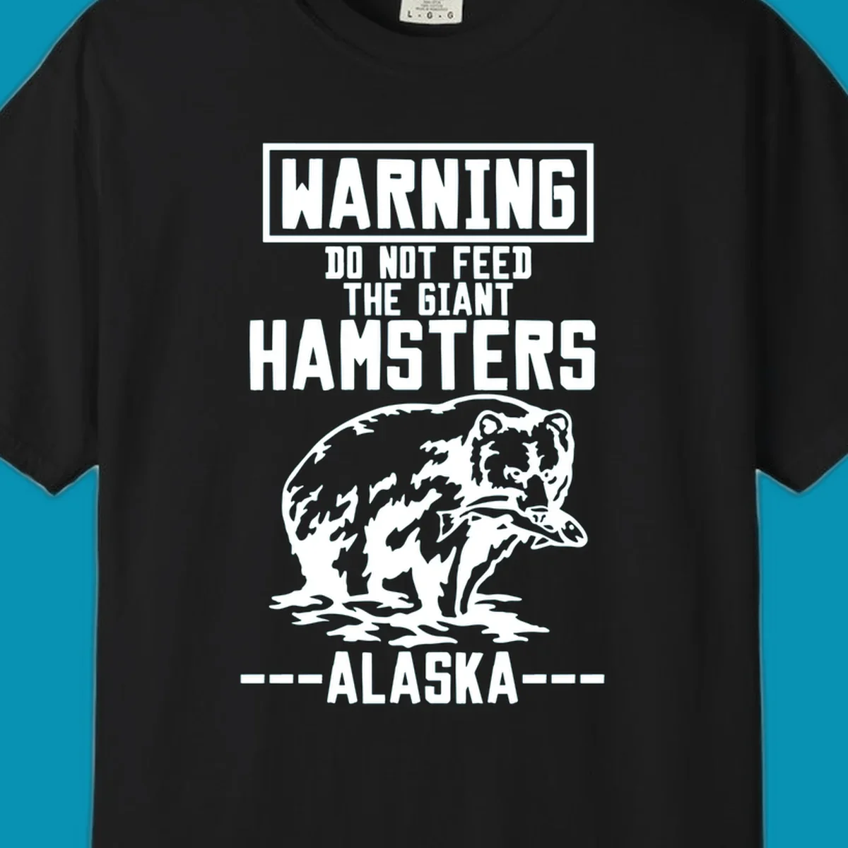 Warning-style design with giant hamster illustration and text reading 'Do Not Feed The Giant Hamsters Alaska' in white lettering on gray background
