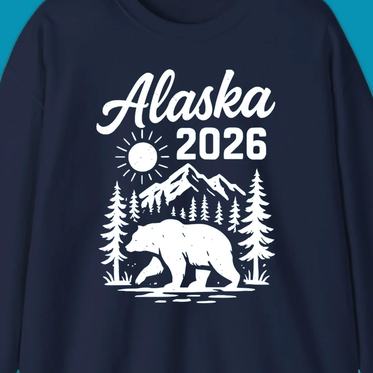 Alaska 2026 design featuring a polar bear walking through snowy mountains surrounded by evergreen trees and bright sun