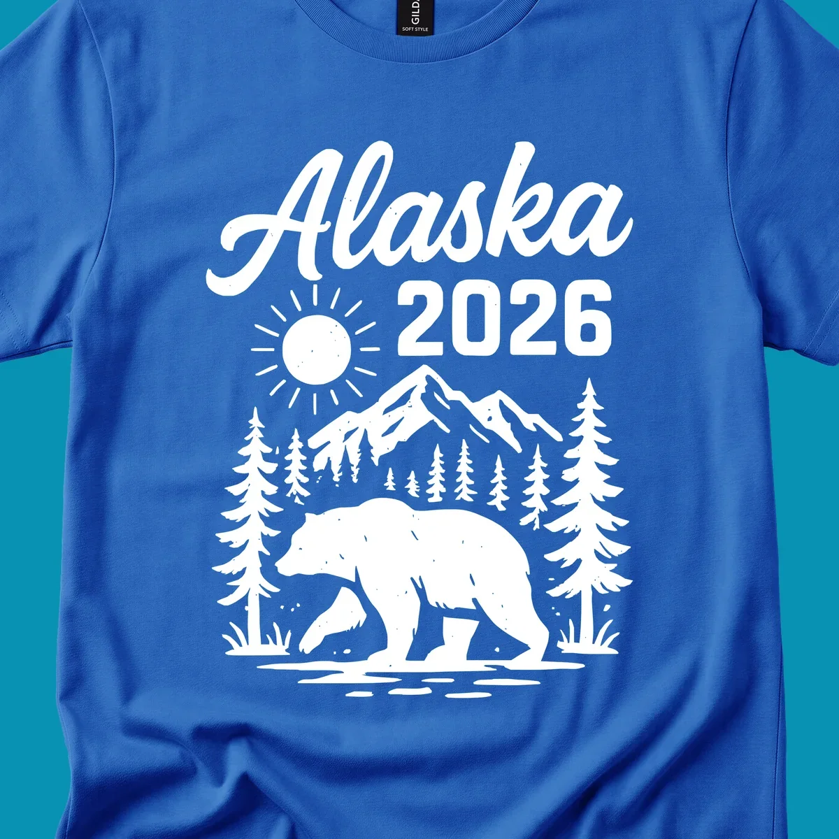 Alaska 2026 design featuring a polar bear walking through snowy mountains surrounded by evergreen trees and bright sun