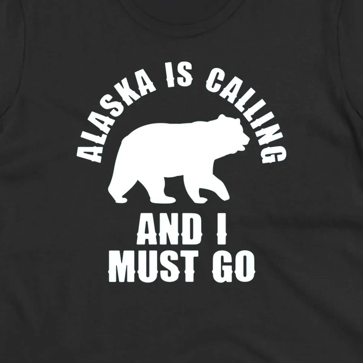 White bear silhouette with curved text reading 'Alaska is calling and I must go' on gray background