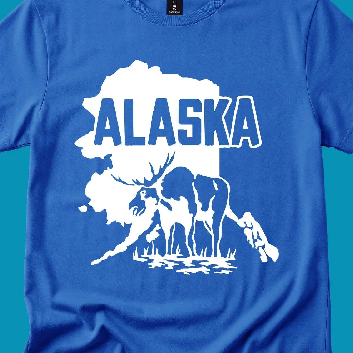 Alaska state map silhouette filled with moose, bear, and eagle wildlife illustrations with grass and water landscape elements