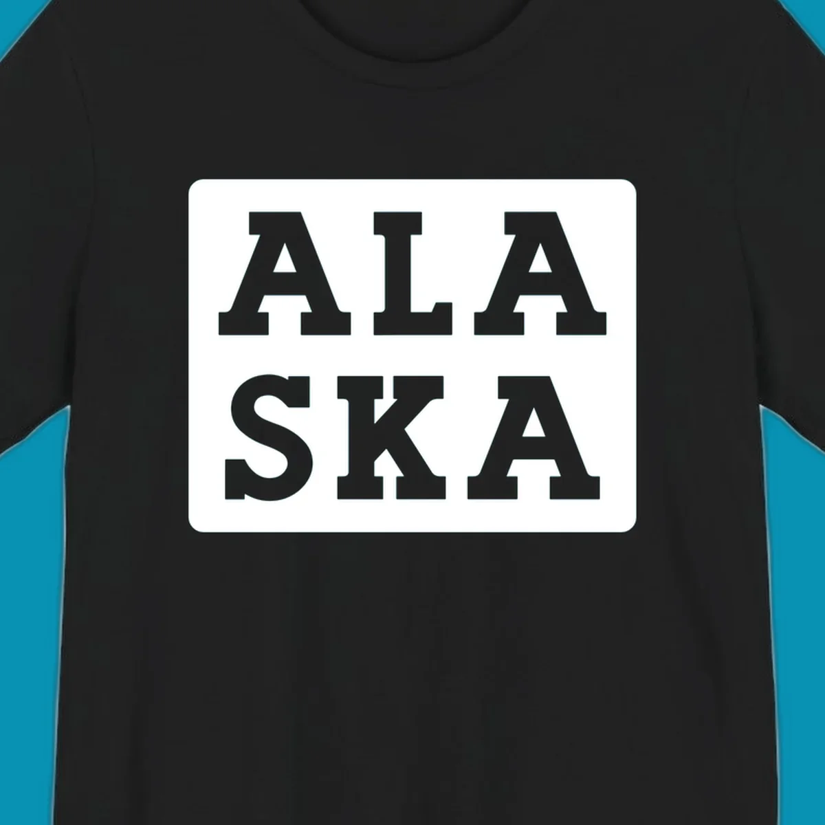 Bold gray block letters spelling 'ALA SKA' with geometric triangle cutouts, creating a playful Alaska pun design