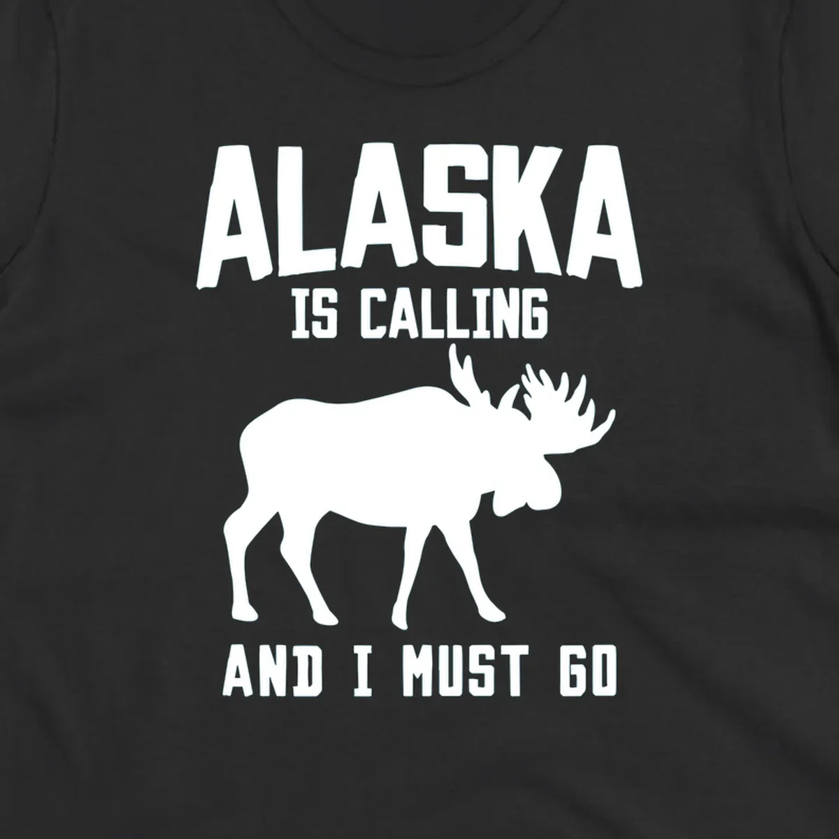 White moose silhouette with text 'Alaska Is Calling And I Must Go' on gray background—Alaska is calling moose design
