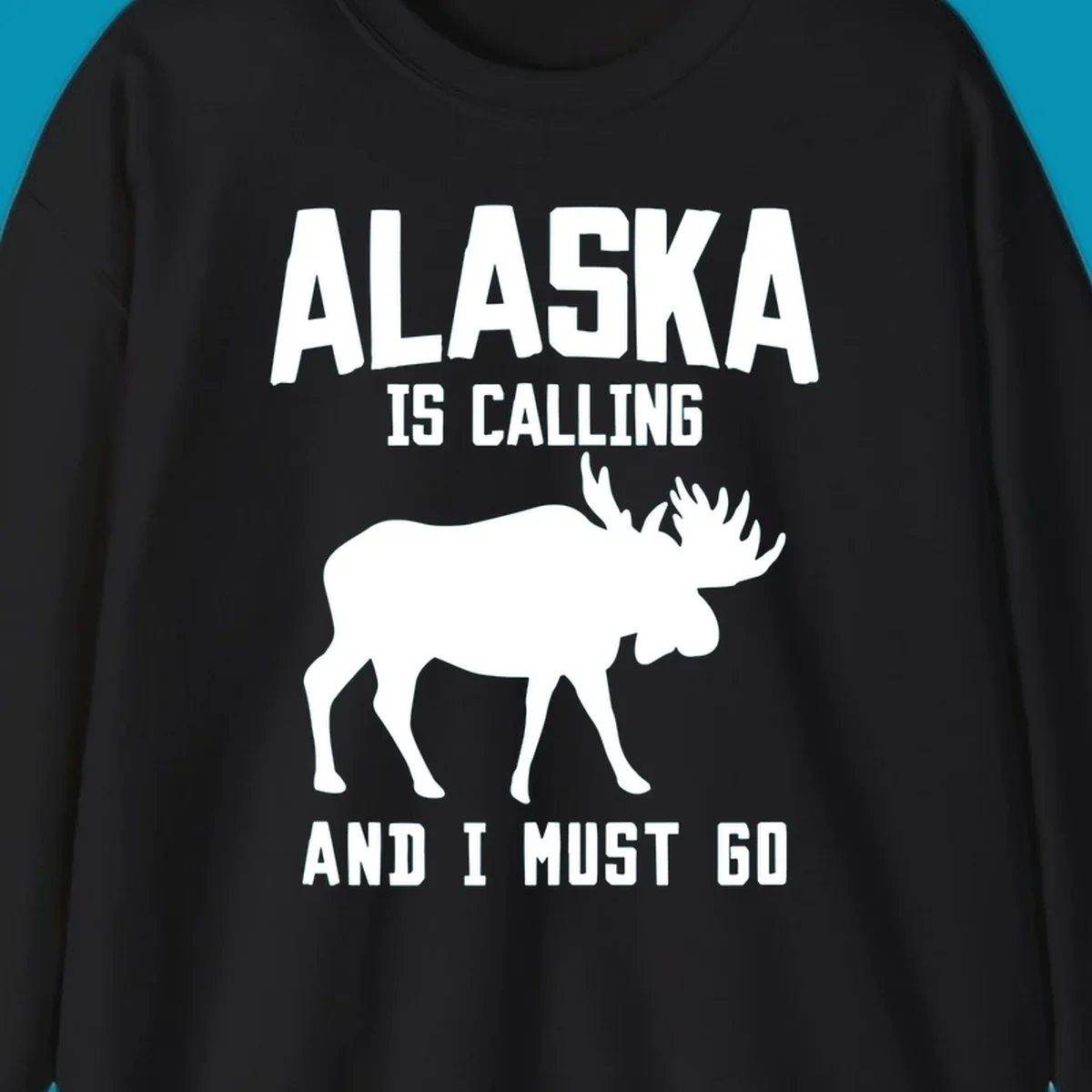 White moose silhouette with text 'Alaska Is Calling And I Must Go' on gray background—Alaska is calling moose design