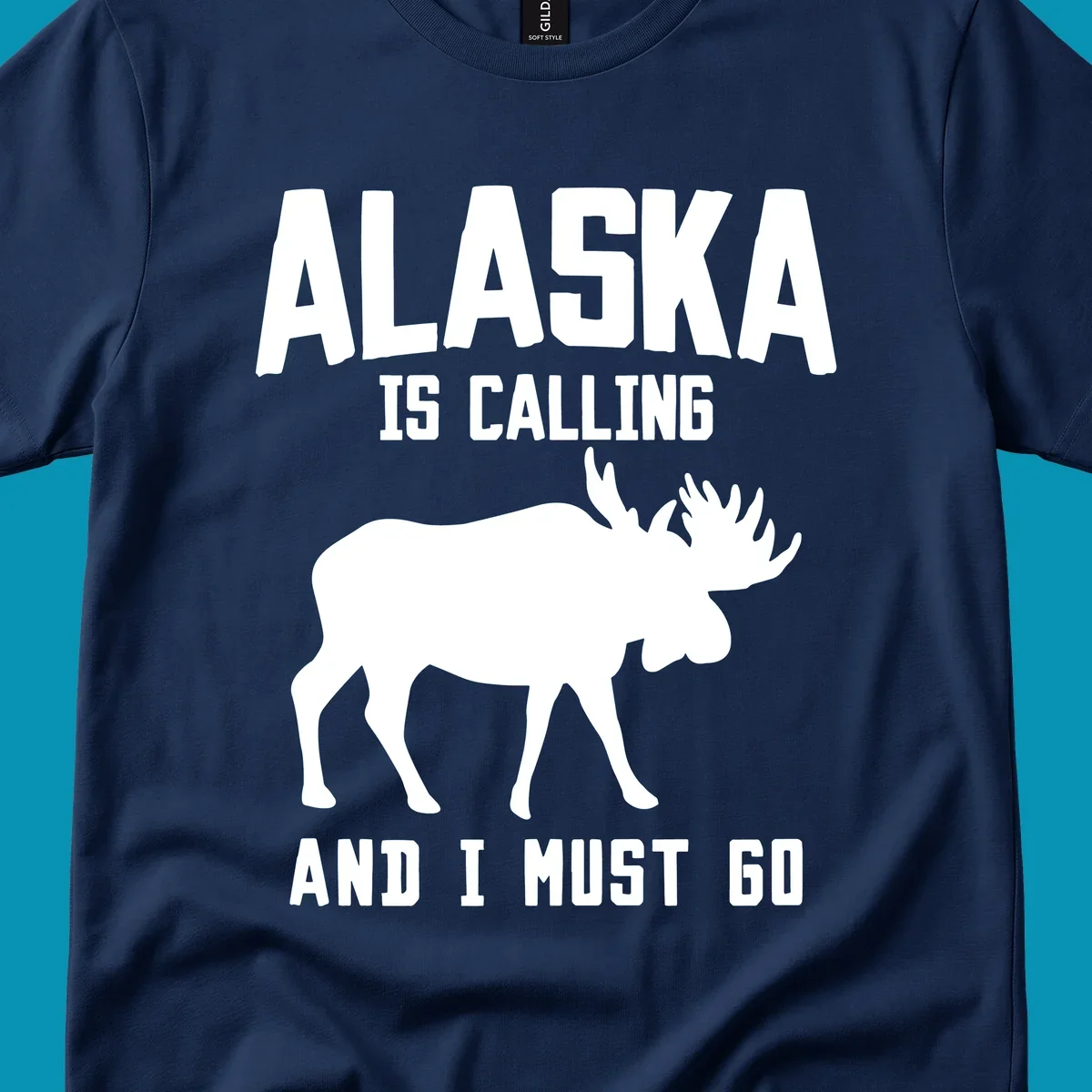 White moose silhouette with text 'Alaska Is Calling And I Must Go' on gray background—Alaska is calling moose design