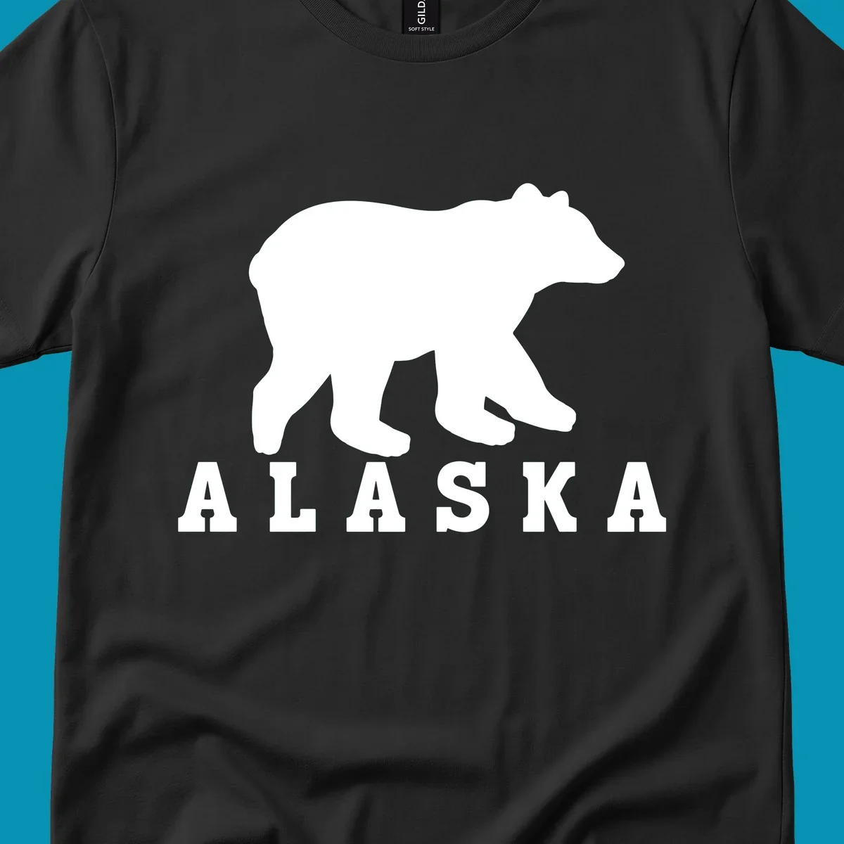 White bear silhouette standing with front paws visible, Alaska text below with pine tree accents on gray background