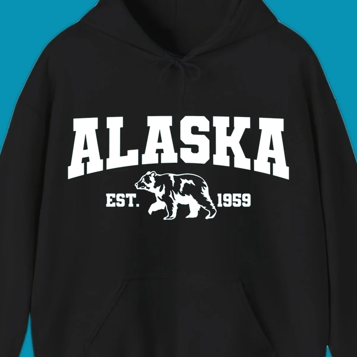 Vintage-style Alaska bear design with distressed lettering, established 1959, featuring pine trees and wildlife illustration