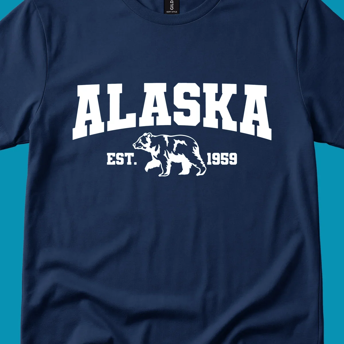Vintage-style Alaska bear design with distressed lettering, established 1959, featuring pine trees and wildlife illustration