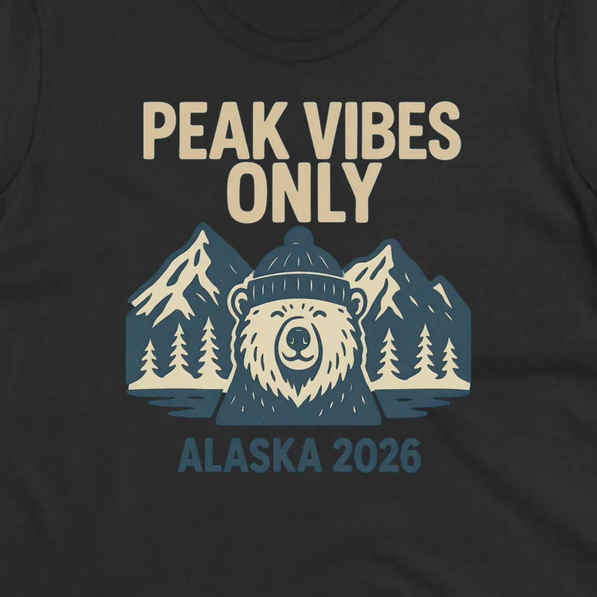 Vintage badge-style illustration of a smiling bear wearing a beanie with snow-capped mountains, evergreen trees, and water, text reads Peak Vibes Only Alaska 2026