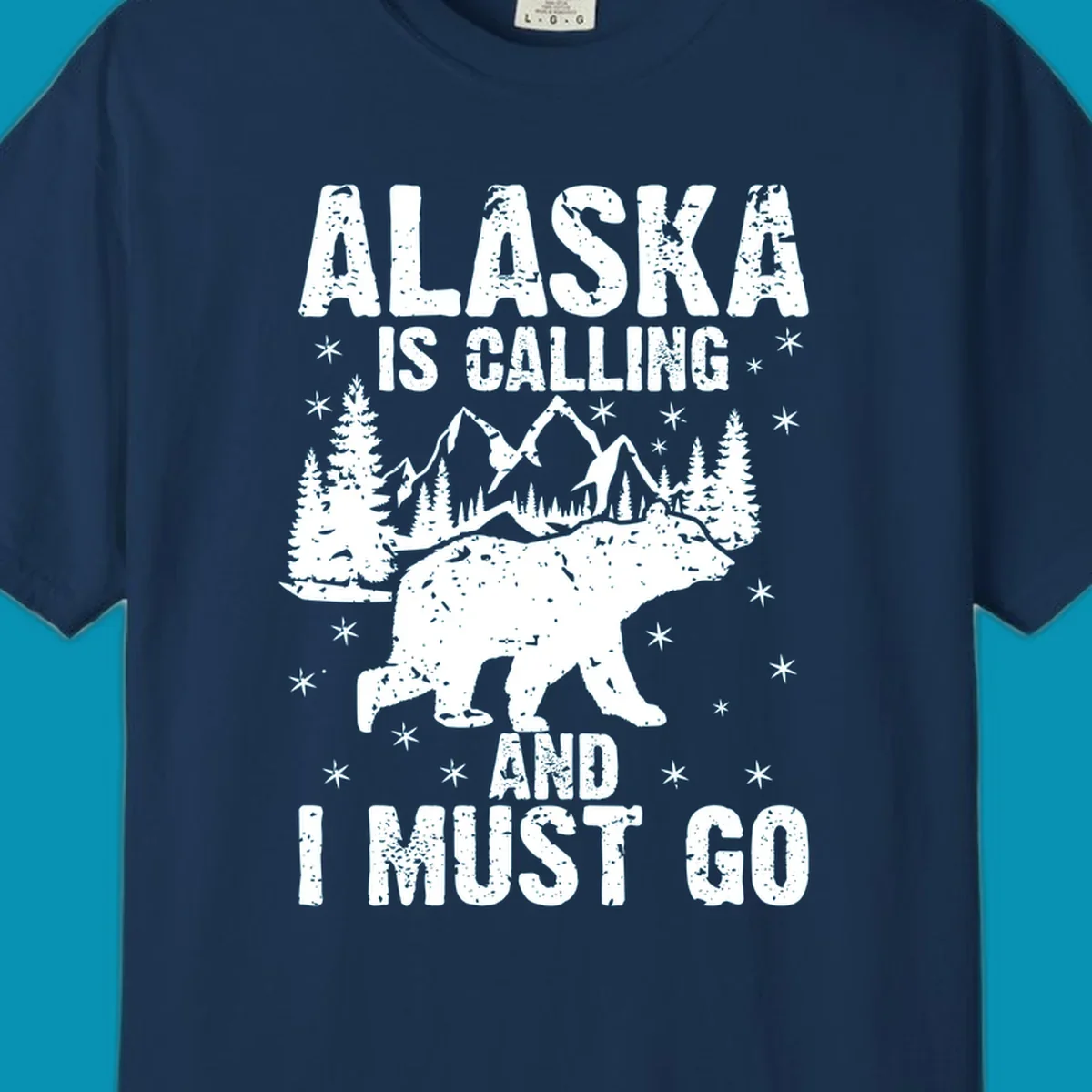 Distressed vintage design with polar bear in snowy mountains, text reads 'Alaska Is Calling And I Must Go'