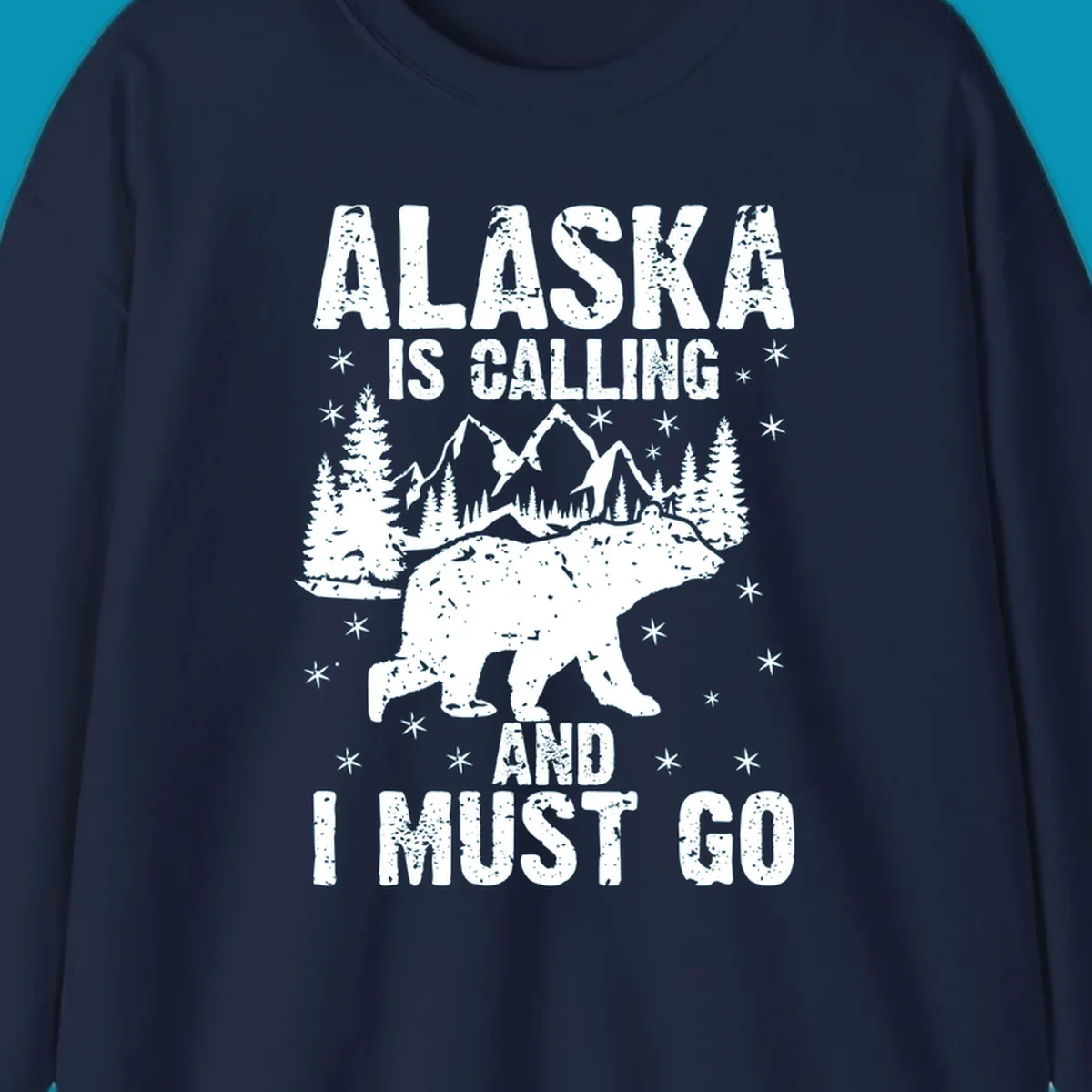 Distressed vintage design with polar bear in snowy mountains, text reads 'Alaska Is Calling And I Must Go'