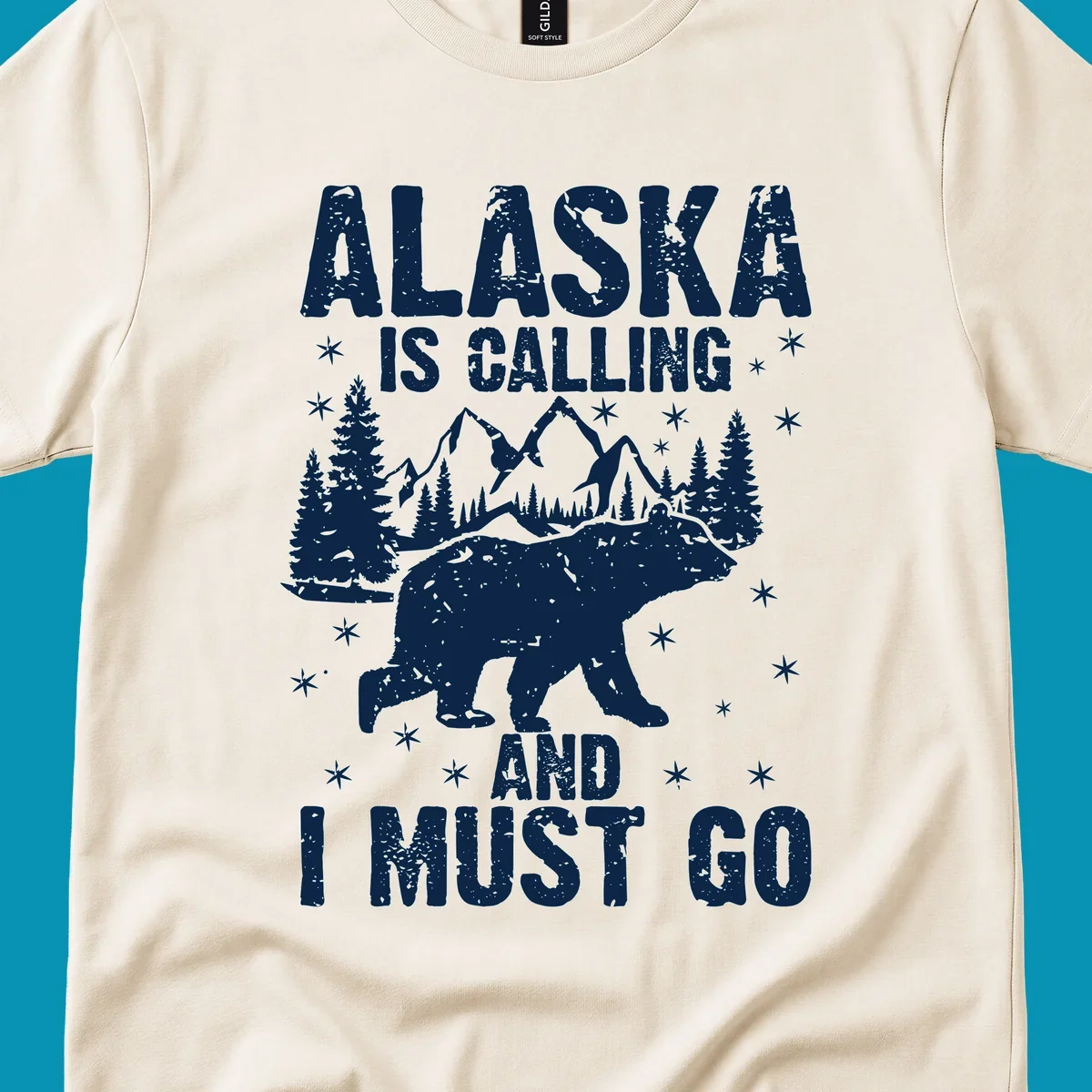 Distressed vintage design with polar bear in snowy mountains, text reads 'Alaska Is Calling And I Must Go'