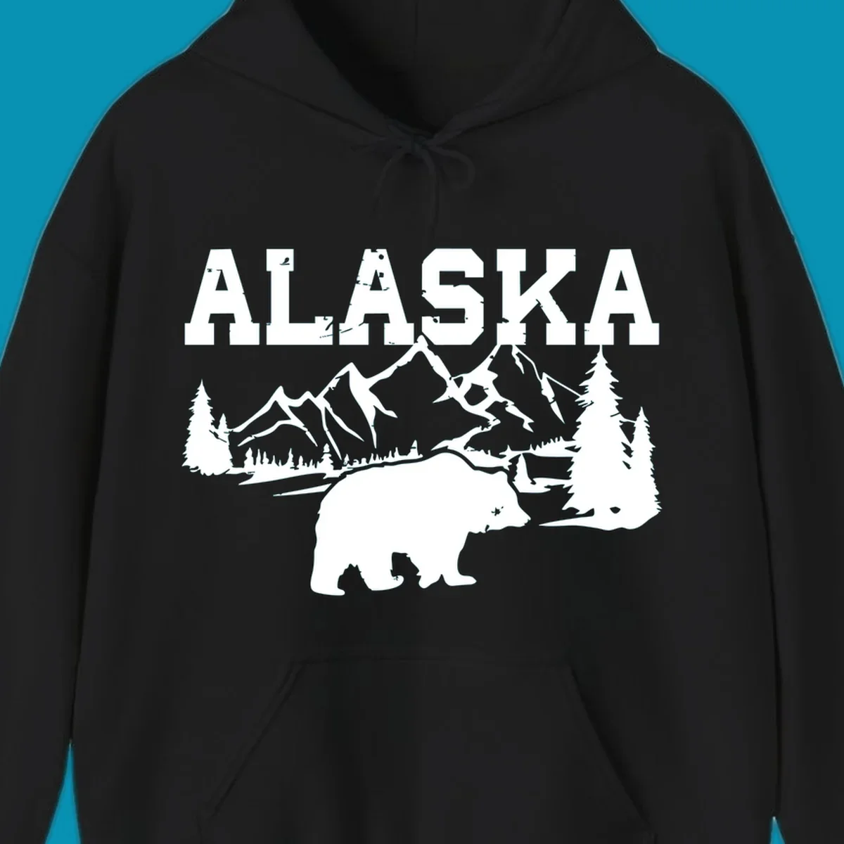 White silhouette illustration of a bear with mountains, evergreen trees, and river landscape under Alaska text on gray background