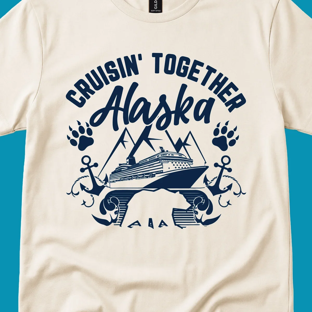 White nautical design on gray background featuring cruise ship between mountains with paw prints and anchors, text reads 'Cruisin' Together Alaska'