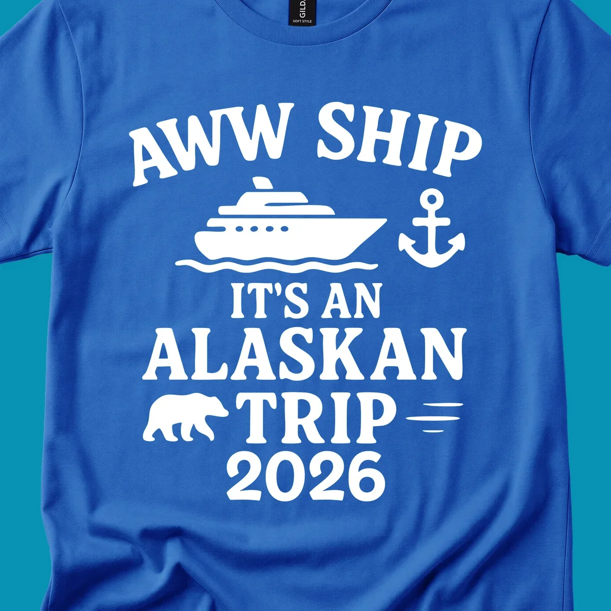 Gray design with white text reading 'Aww Ship It's An Alaskan Trip 2026' featuring a cruise ship, anchor, bear silhouette, and ocean waves
