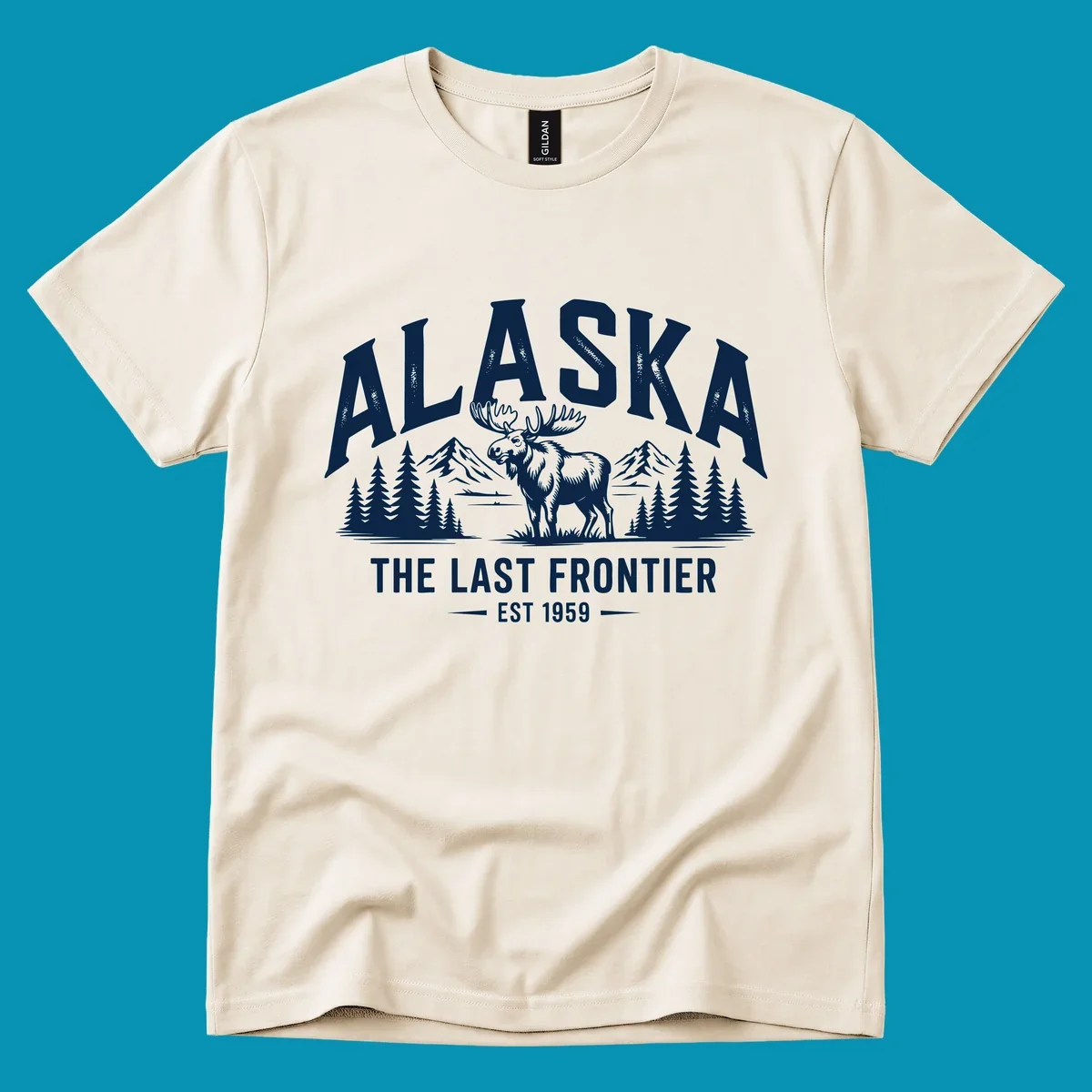 A white alaska-moose-frontier-scenic graphic showing a moose standing in front of mountains and pine trees.