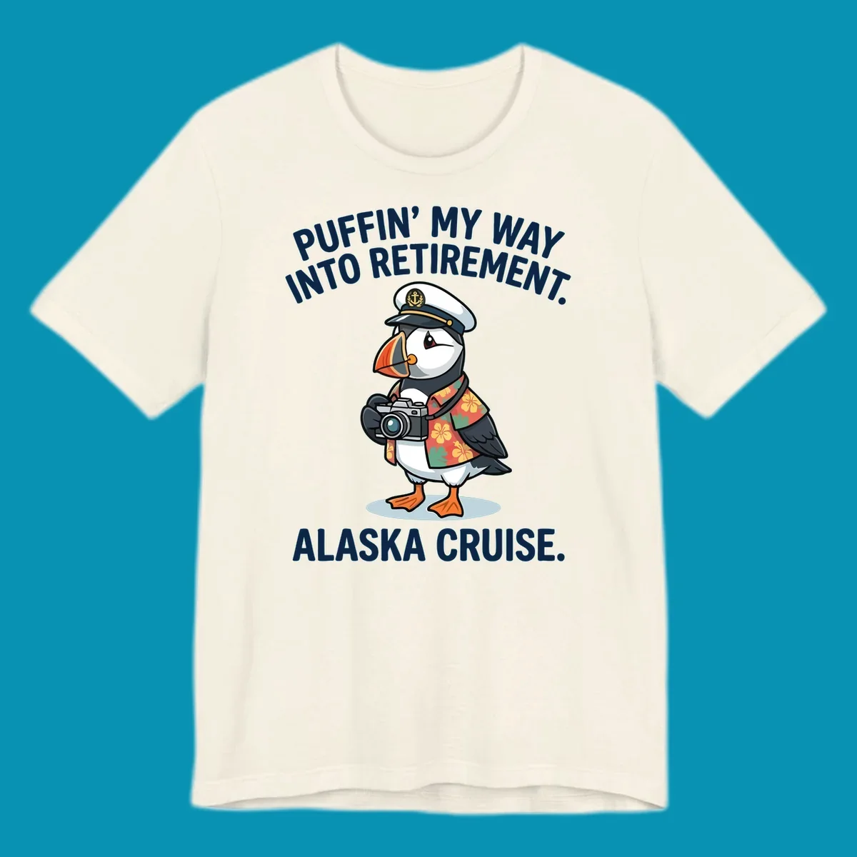 A cartoon puffin wearing a captain's hat and Hawaiian shirt holds a camera, with text 'PUFFIN' INTO MY RETIREMENT. ALASKA CRUISE.' for a puffin-into-retirement-cruise.
