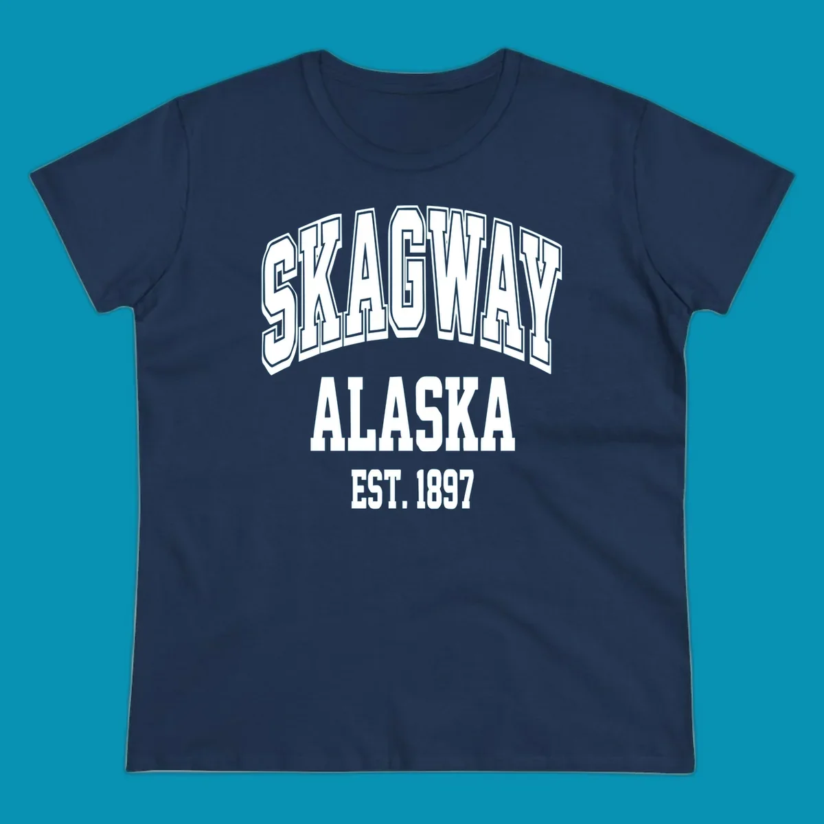 Vintage-style badge with bold outlined text reading Skagway Alaska Est. 1897 with decorative arrow accents on gray background.