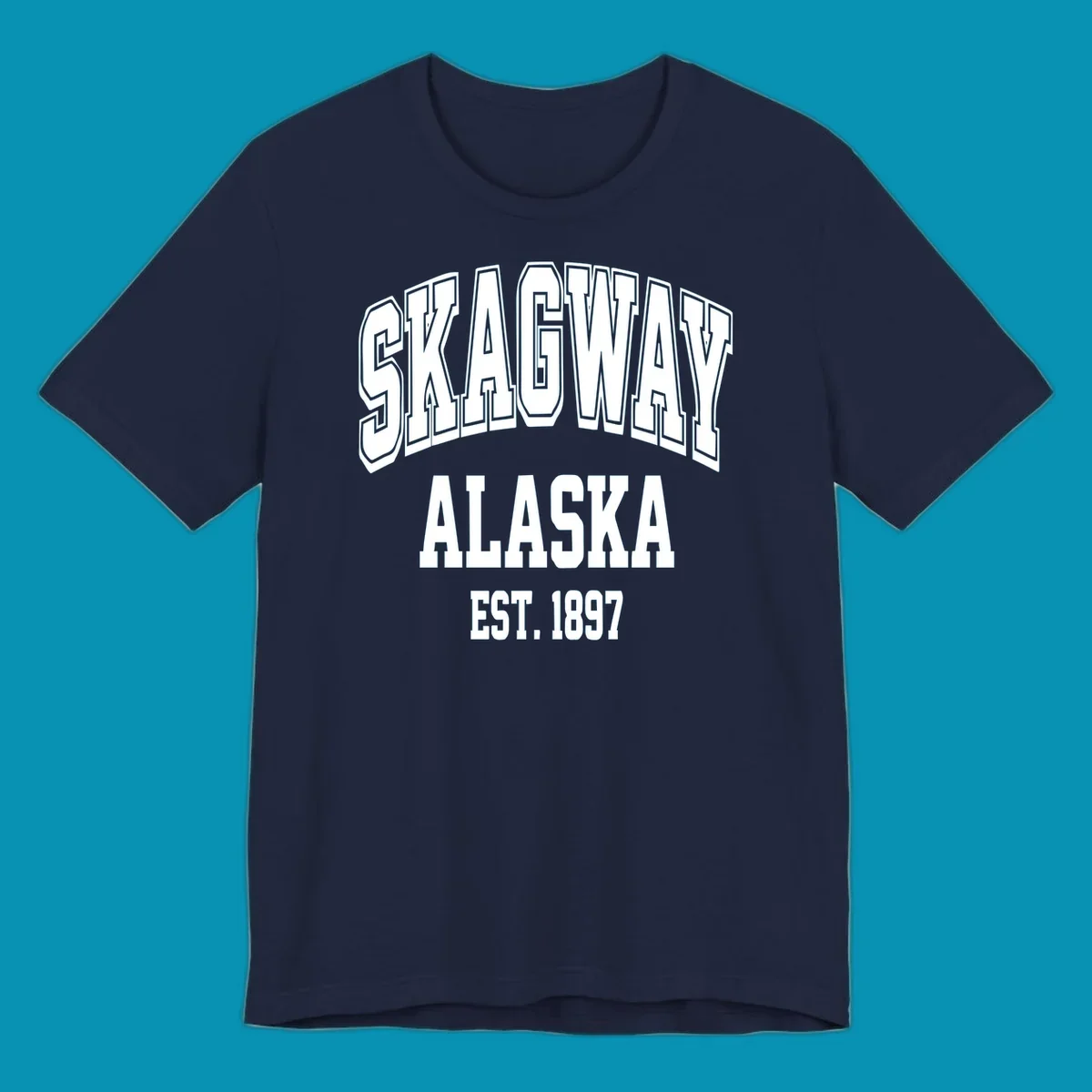Vintage-style badge with bold outlined text reading Skagway Alaska Est. 1897 with decorative arrow accents on gray background.