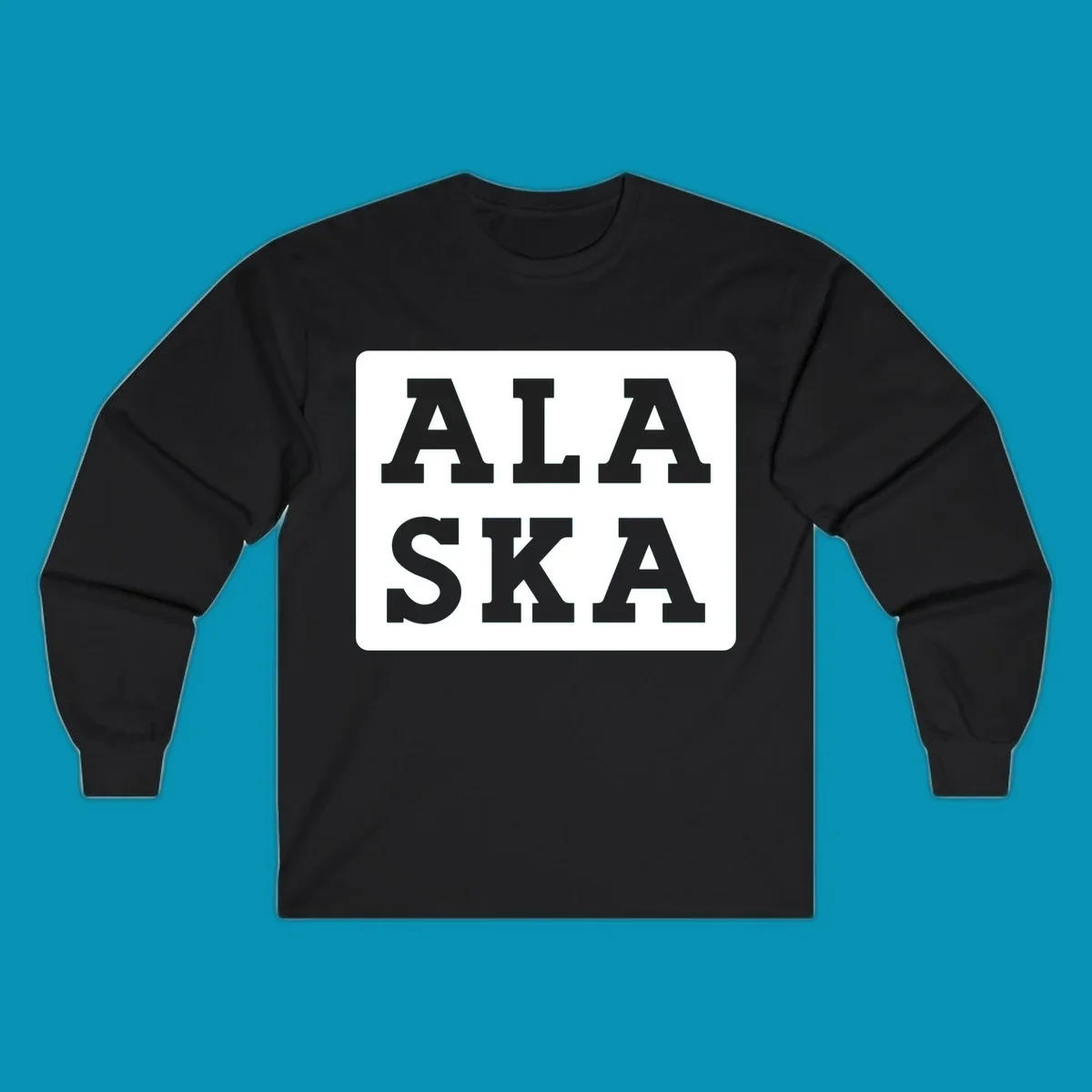 Bold gray block letters spelling 'ALA SKA' with geometric triangle cutouts, creating a playful Alaska pun design