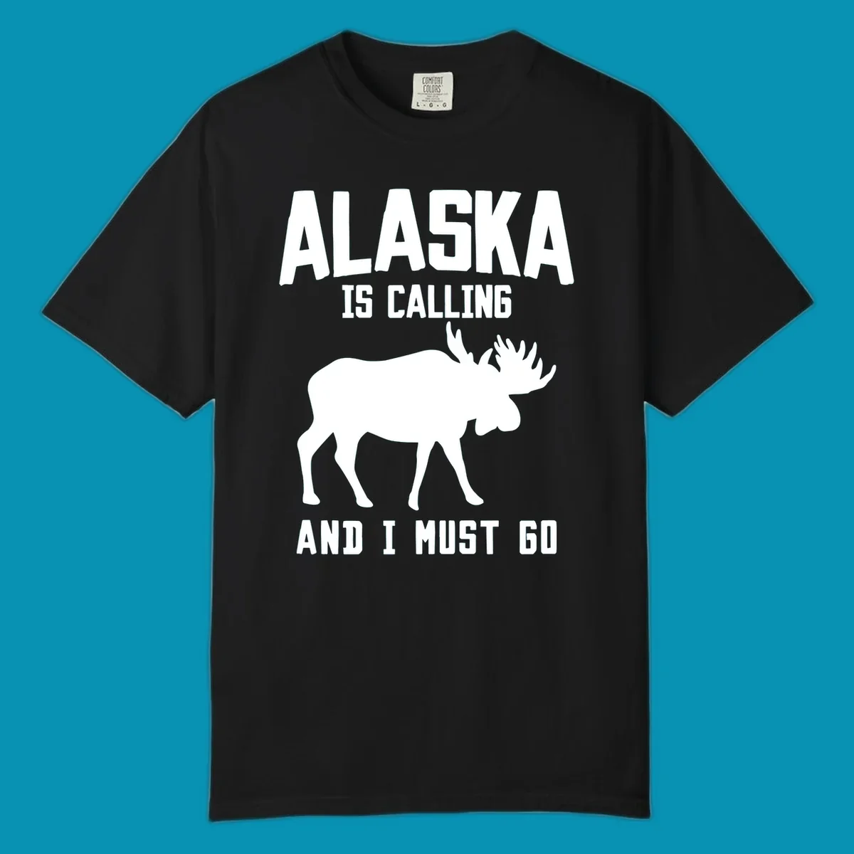 White moose silhouette with text 'Alaska Is Calling And I Must Go' on gray background—Alaska is calling moose design