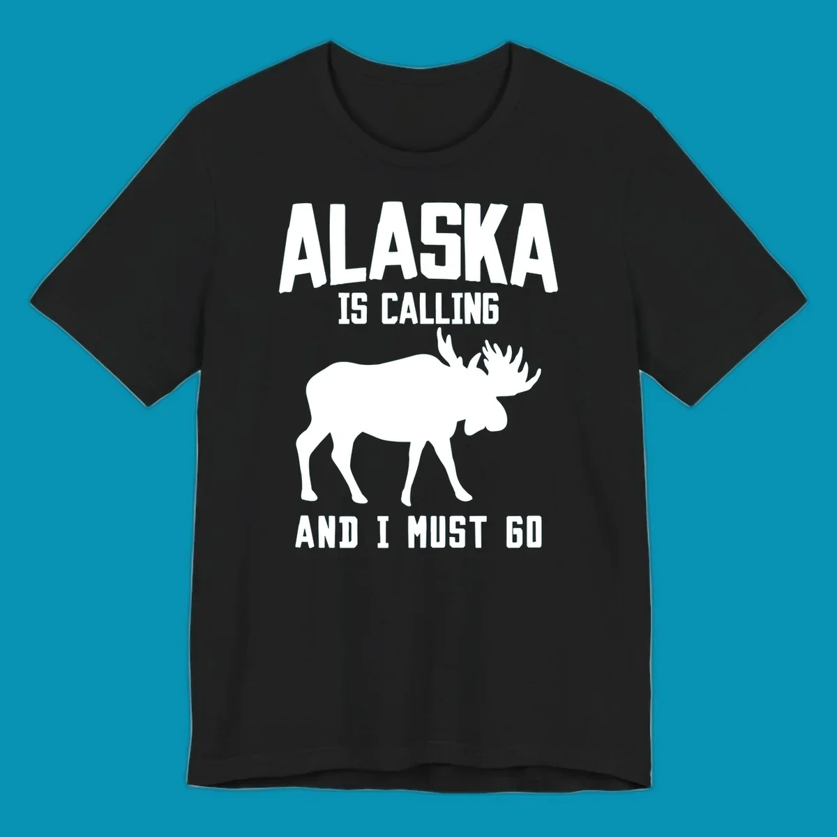 White moose silhouette with text 'Alaska Is Calling And I Must Go' on gray background—Alaska is calling moose design