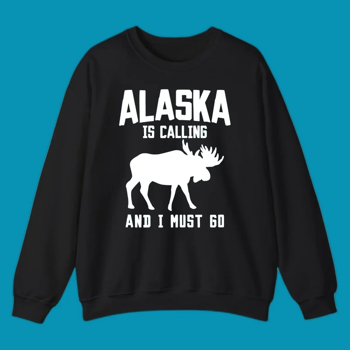 White moose silhouette with text 'Alaska Is Calling And I Must Go' on gray background—Alaska is calling moose design