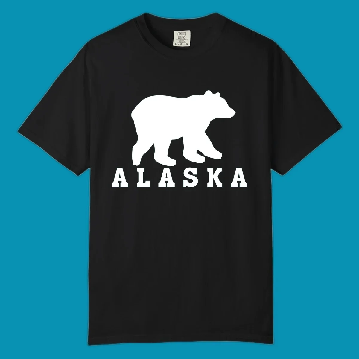 White bear silhouette standing with front paws visible, Alaska text below with pine tree accents on gray background