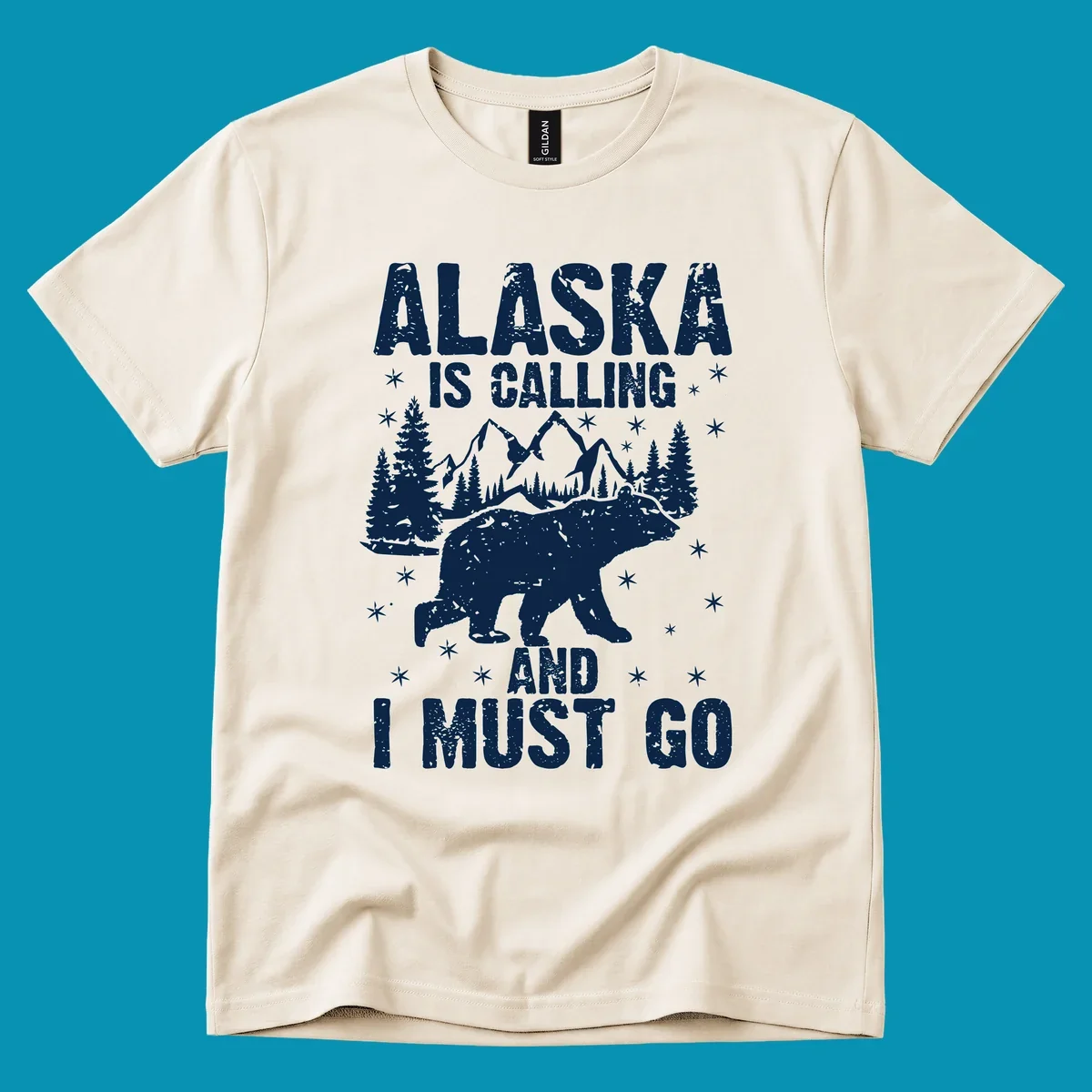Distressed vintage design with polar bear in snowy mountains, text reads 'Alaska Is Calling And I Must Go'