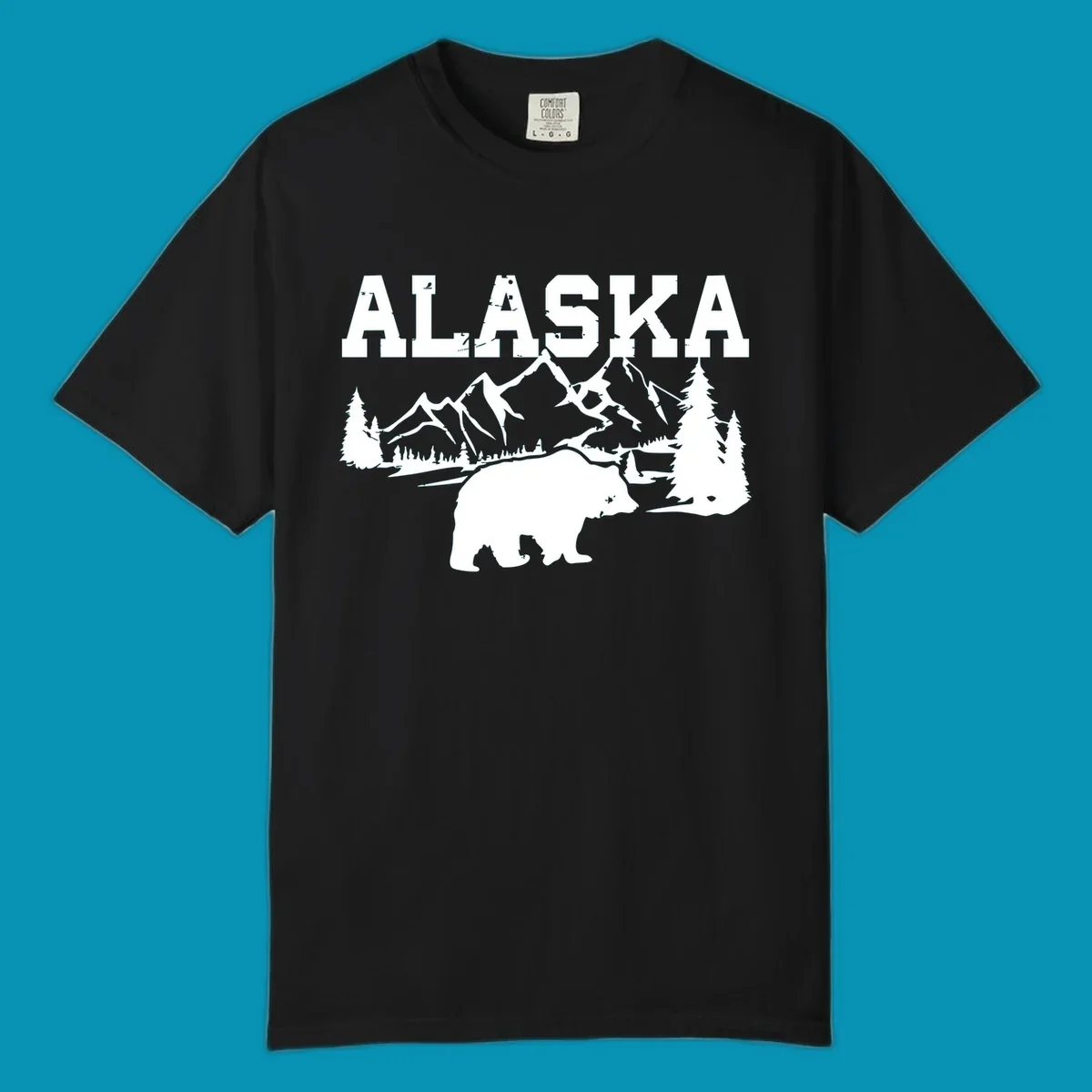 White silhouette illustration of a bear with mountains, evergreen trees, and river landscape under Alaska text on gray background