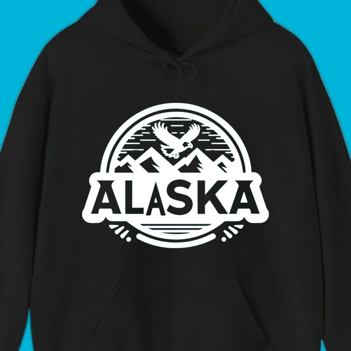 An oval badge design with a bald eagle flying above mountains and water, and the word ALASKA in bold text; alaska-eagle-mountain-badge.