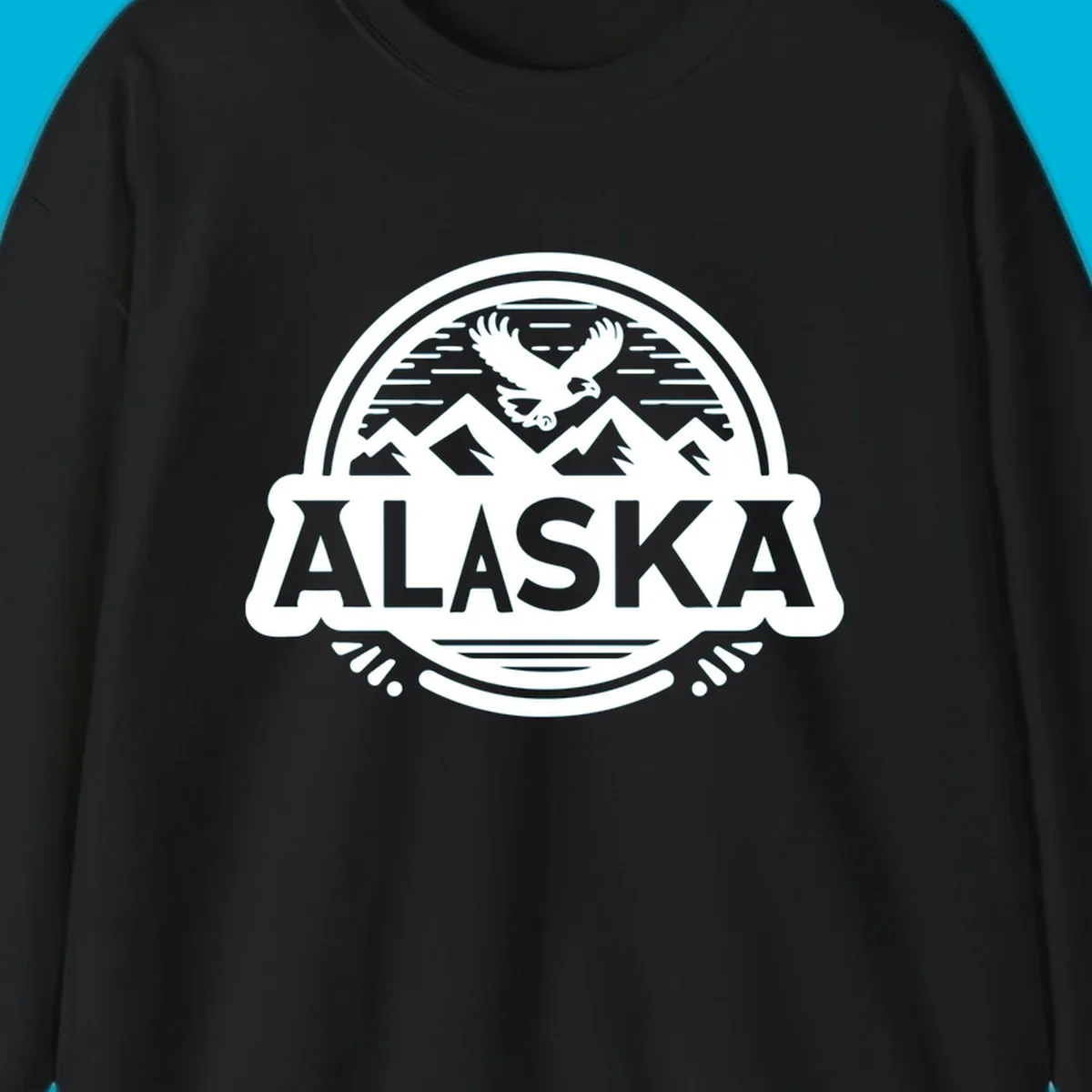 An oval badge design with a bald eagle flying above mountains and water, and the word ALASKA in bold text; alaska-eagle-mountain-badge.