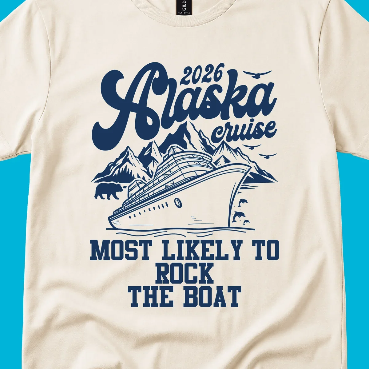 An illustrated Alaska cruise rock the boat design with a ship, mountains, bear, dolphins, and birds.