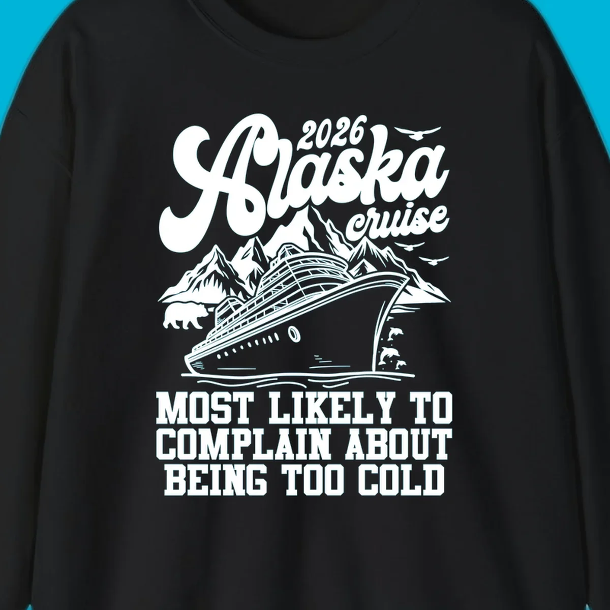 A white design on a black background of a cruise ship, mountains, bear, dolphins, and text "2026 Alaska cruise MOST LIKELY TO COMPLAIN ABOUT BEING TOO COLD".