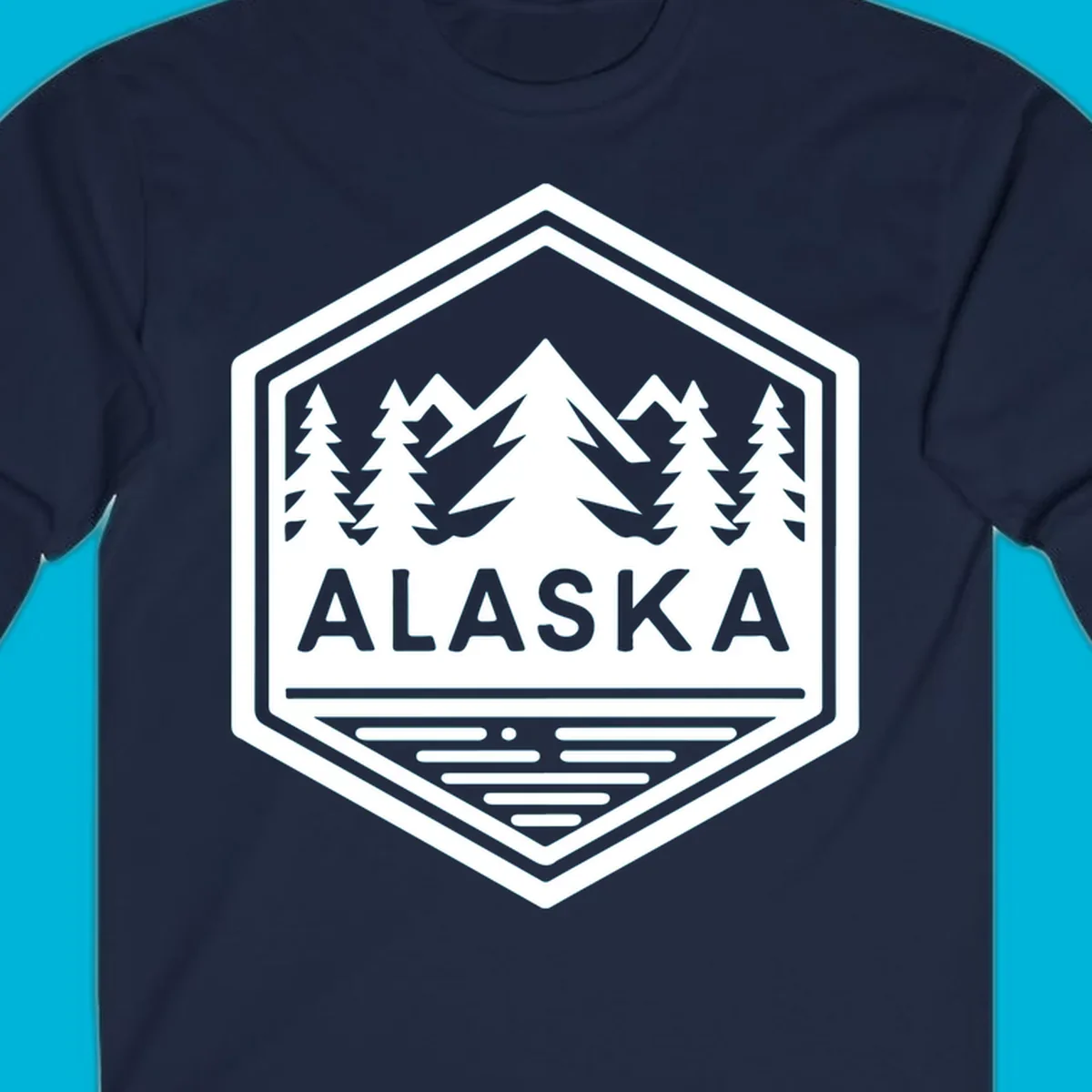 An Alaska mountain lake badge design in a hexagon shape, showing mountains, pine trees, and a lake below the ALASKA text.