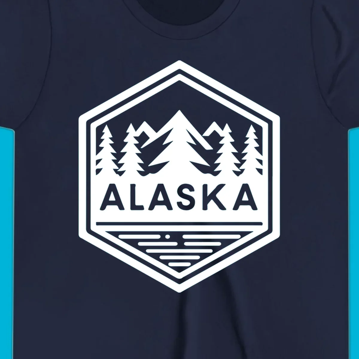 An Alaska mountain lake badge design in a hexagon shape, showing mountains, pine trees, and a lake below the ALASKA text.